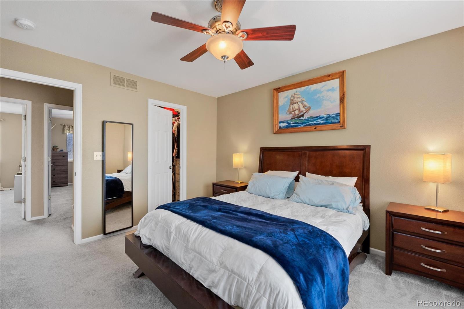 9836 South Castle Ridge Circle Highlands Ranch, CO 80129 - Photo 11 of 28 a spacious bedroom with a bed and a chandelier