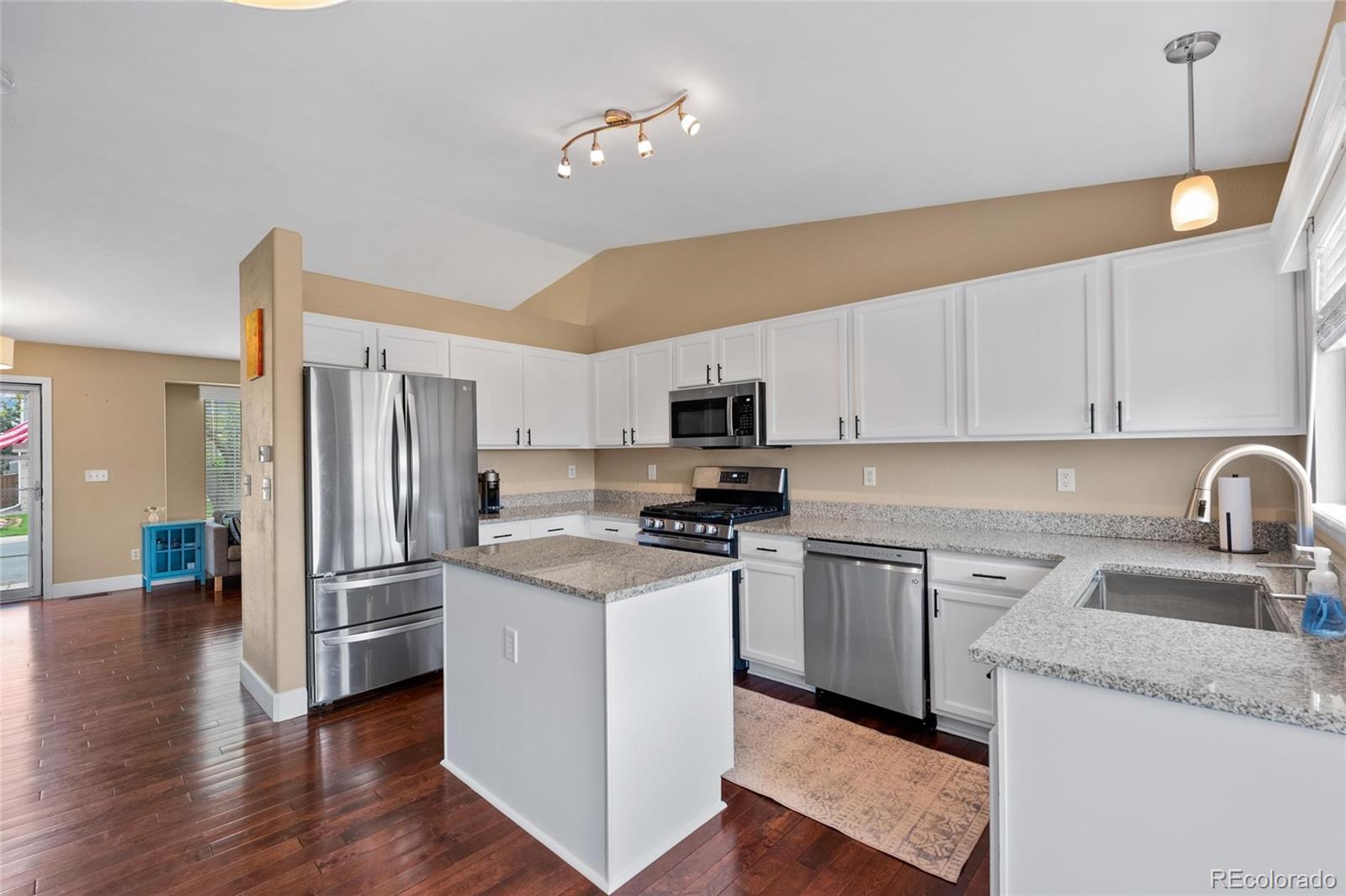 9836 South Castle Ridge Circle Highlands Ranch, CO 80129 - Photo 4 of 28 a kitchen with granite countertop a refrigerator stove and sink