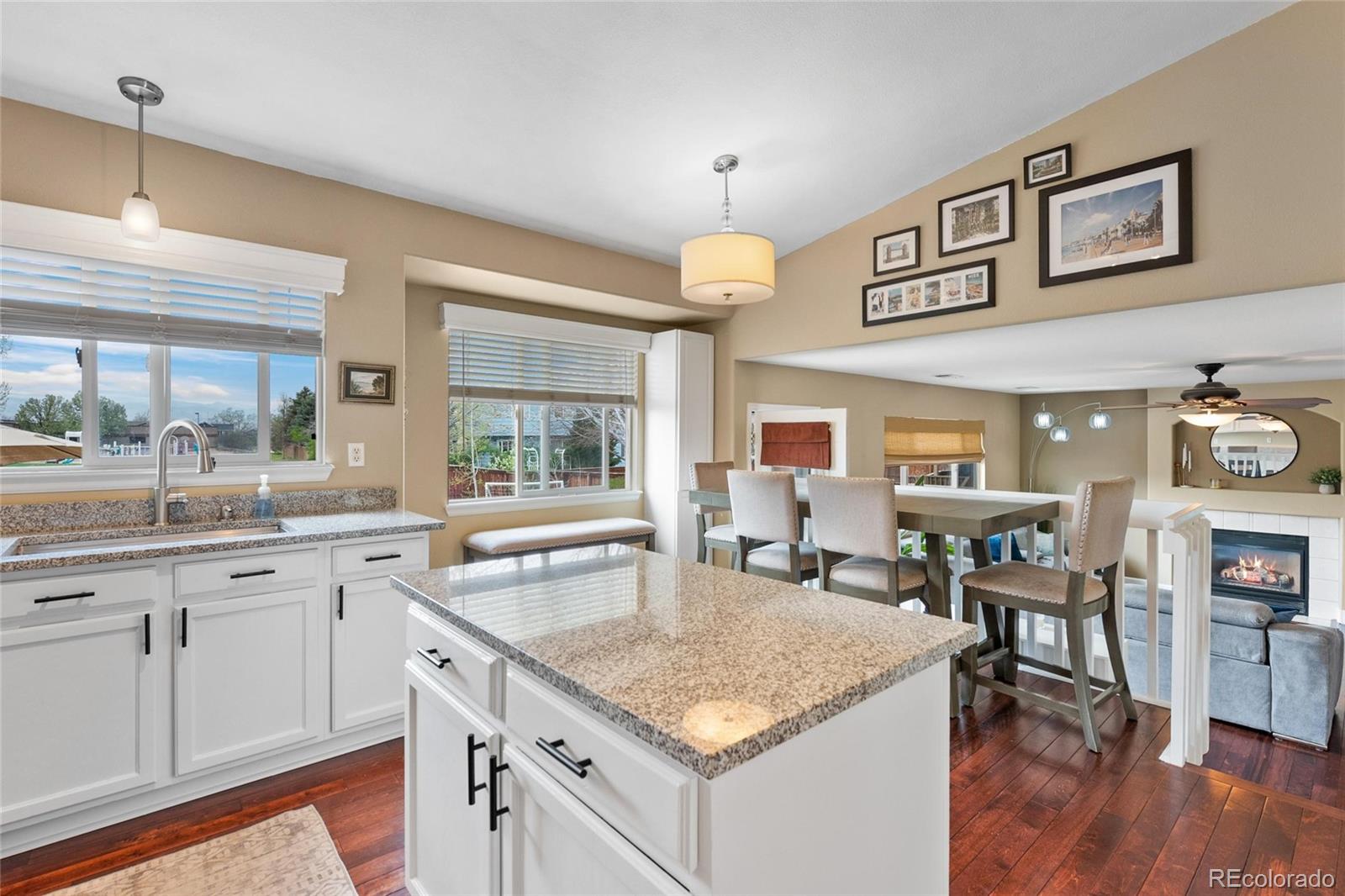 9836 South Castle Ridge Circle Highlands Ranch, CO 80129 - Photo 6 of 28 a kitchen with a stove a sink a dining table and chairs