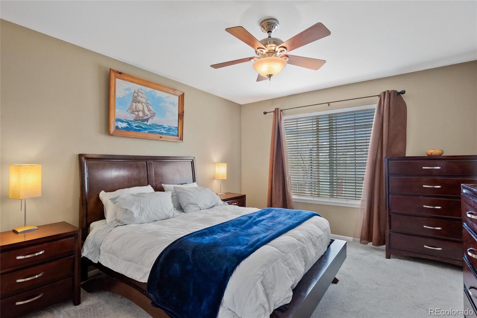 9836 South Castle Ridge Circle Highlands Ranch, CO 80129 - Photo 10 of 28 a bedroom with a bed a chandelier and a painting on the wall
