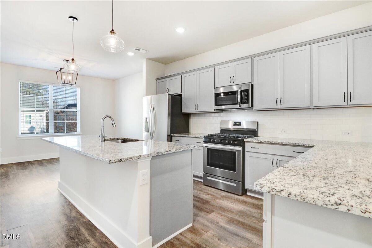 857 South Franklin Street Wake Forest, NC 27587 - Photo 11 of 30 a kitchen with stainless steel appliances granite countertop a stove a sink and a refrigerator