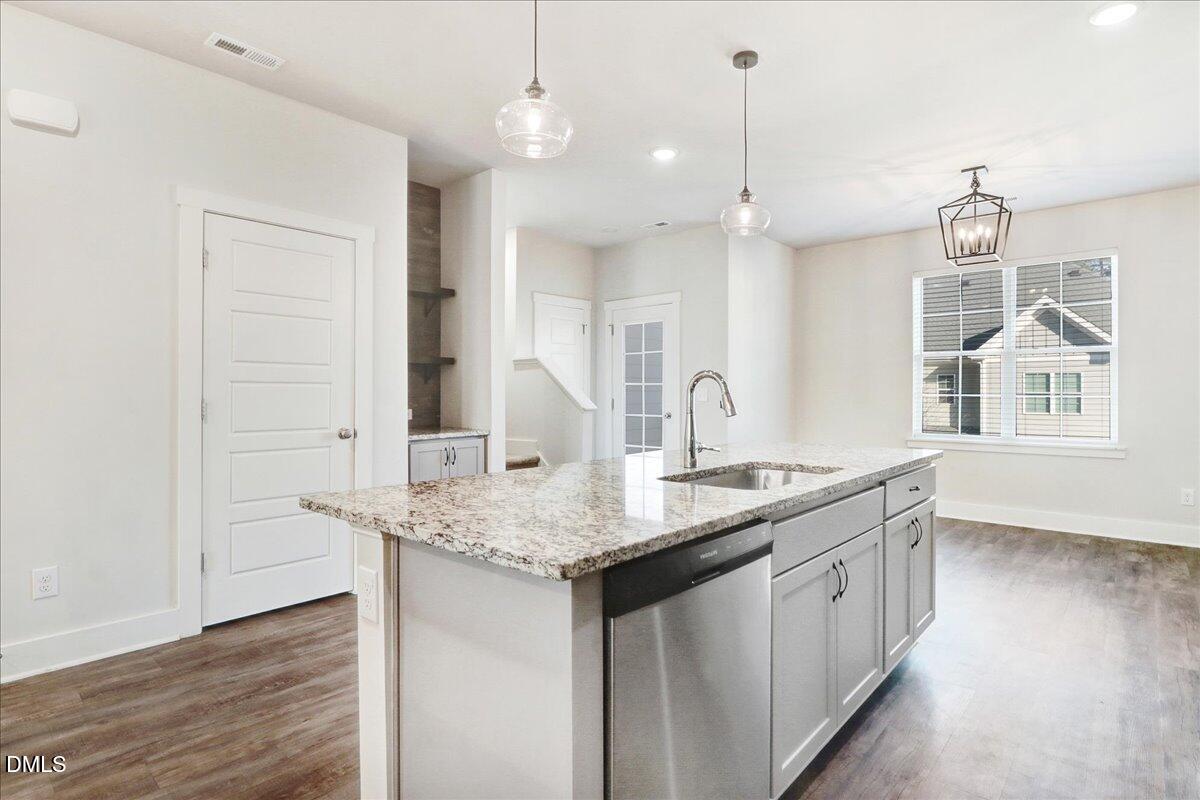 857 South Franklin Street Wake Forest, NC 27587 - Photo 12 of 30 a kitchen with center island wooden floor and a chandelier