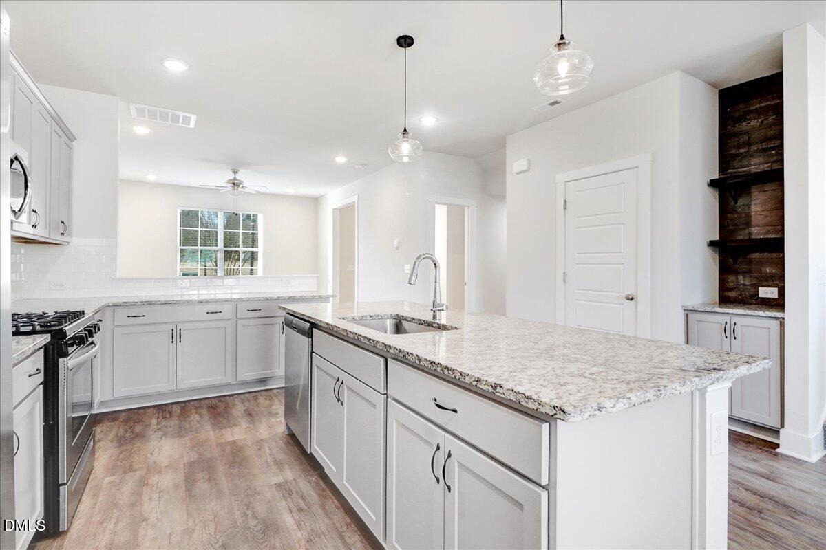 857 South Franklin Street Wake Forest, NC 27587 - Photo 13 of 30 a kitchen with granite countertop a sink a counter space appliances and cabinets