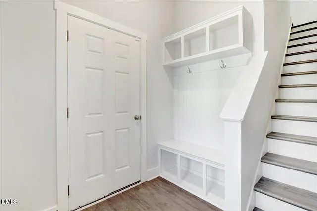 a view of a hallway with wooden floor and entryway