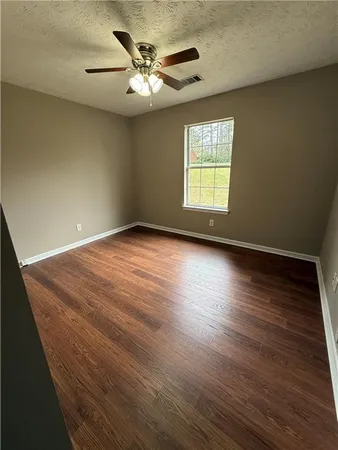 a view of an empty room window and wooden floor