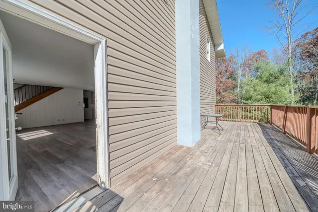 a view of a balcony with wooden floor and fence
