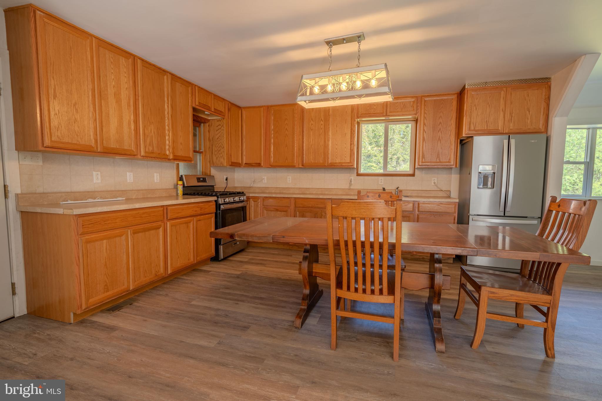 644 Madisonburg Pike Road Madisonburg, PA 16852 - Photo 5 of 44 a open kitchen with stainless steel appliances granite countertop a stove top oven a refrigerator a dining table and chairs with wooden floor