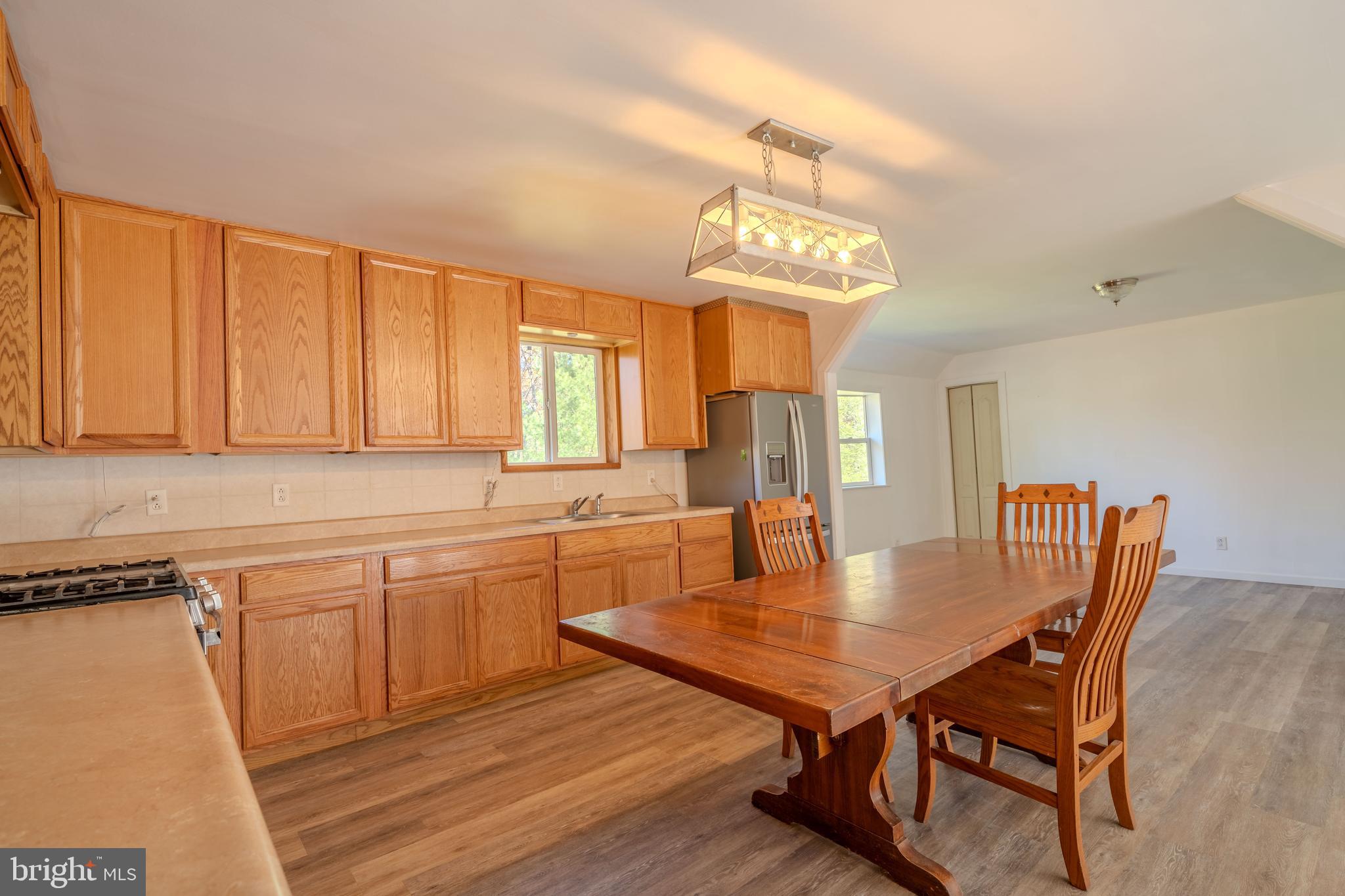 644 Madisonburg Pike Road Madisonburg, PA 16852 - Photo 7 of 44 a dining room with wooden floor a chandelier a wooden table and chairs