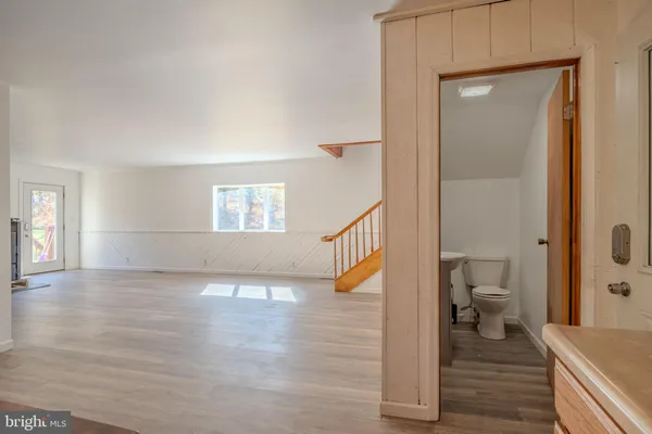 a view of a hallway with wooden floor and a living room