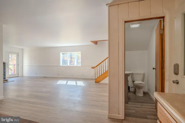 a view of a hallway with wooden floor and a living room