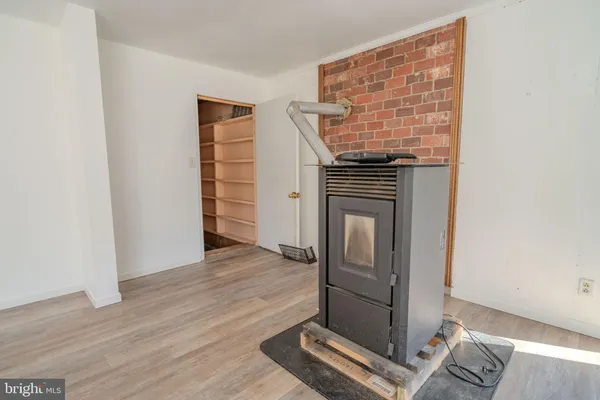 an empty room with wooden floor cabinet and windows