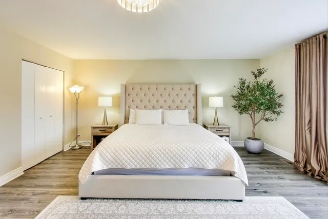 a spacious bedroom with a bed and a potted plant