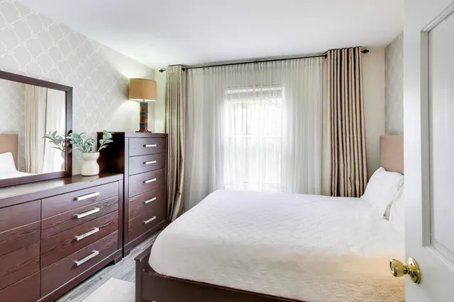 a bedroom with a large bed and a dresser