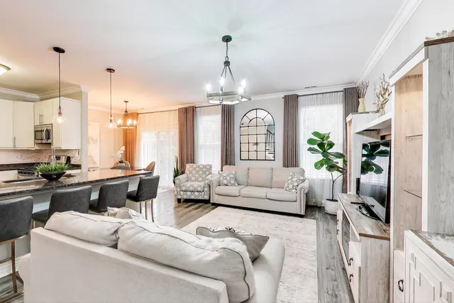 a living room with furniture or chandelier and a wooden floor
