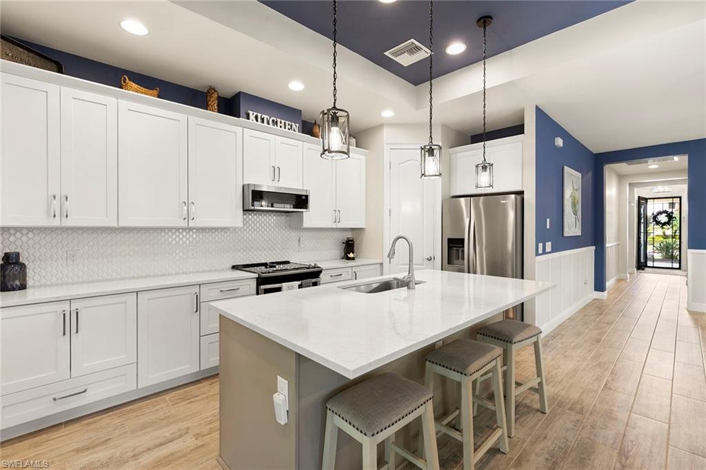 14796 Windward Lane Naples, FL 34114 - Photo 13 of 50 a kitchen with a sink a microwave a stove and refrigerator