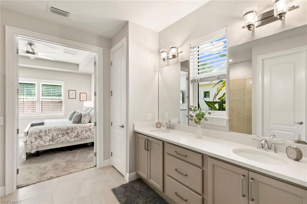 14796 Windward Lane Naples, FL 34114 - Photo 21 of 50 a en suite bathroom with a double sink and mirror