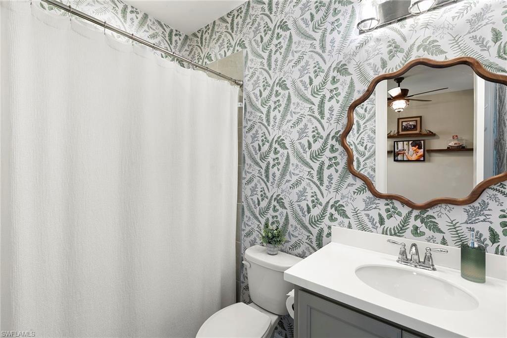 14796 Windward Lane Naples, FL 34114 - Photo 23 of 50 a bathroom with a sink and mirror with toilet