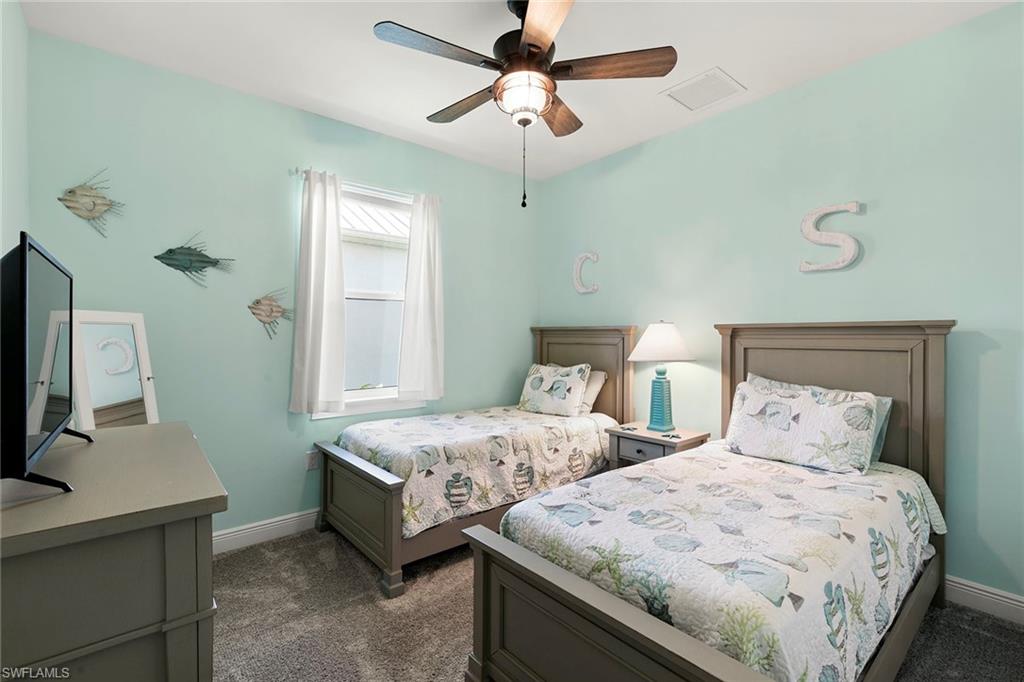 14796 Windward Lane Naples, FL 34114 - Photo 26 of 50 a bedroom with two beds and a chandelier