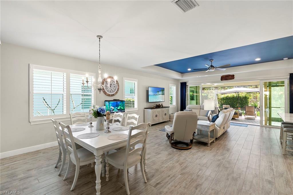 14796 Windward Lane Naples, FL 34114 - Photo 9 of 50 a view of a dining room with furniture wooden floor and chandelier