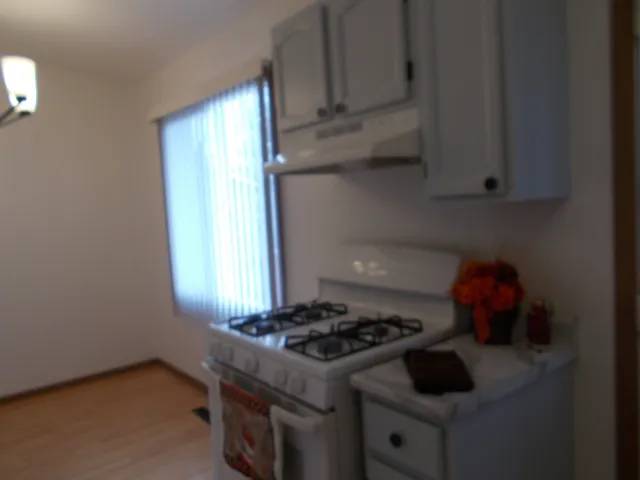 a stove top oven sitting inside of a kitchen