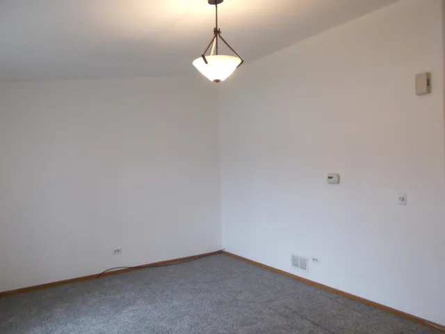 a room with a chandelier fan and window