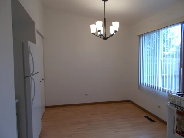 a view of a livingroom with a chandelier a ceiling fan and window
