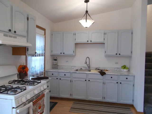 a kitchen with stainless steel appliances granite countertop a sink stove and cabinets