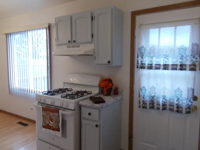 a kitchen with granite countertop white cabinets and window