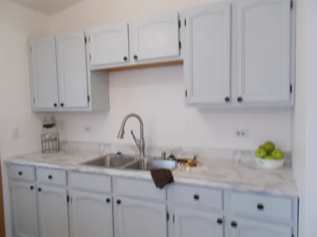 a kitchen with white cabinets and a sink