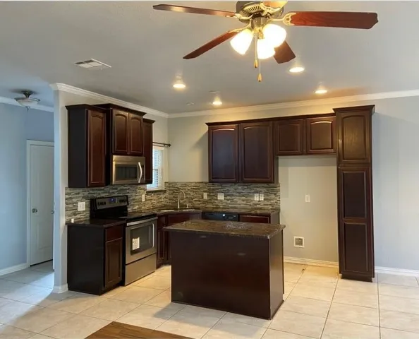 a kitchen with stainless steel appliances granite countertop a stove and a refrigerator