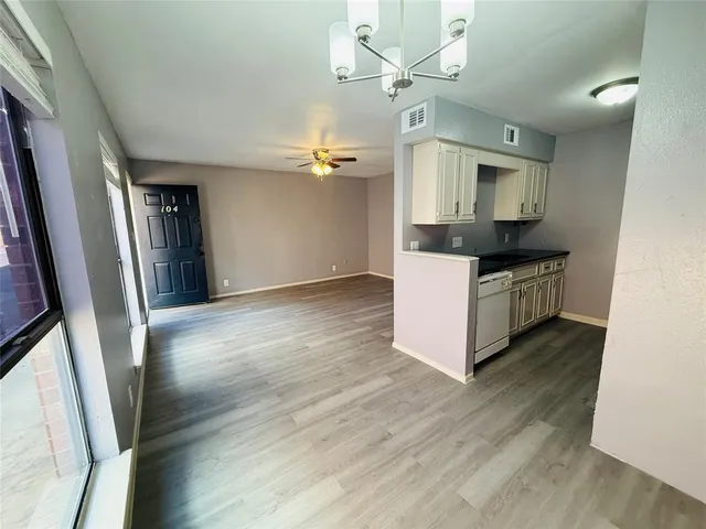a kitchen with stainless steel appliances a sink and wooden floor