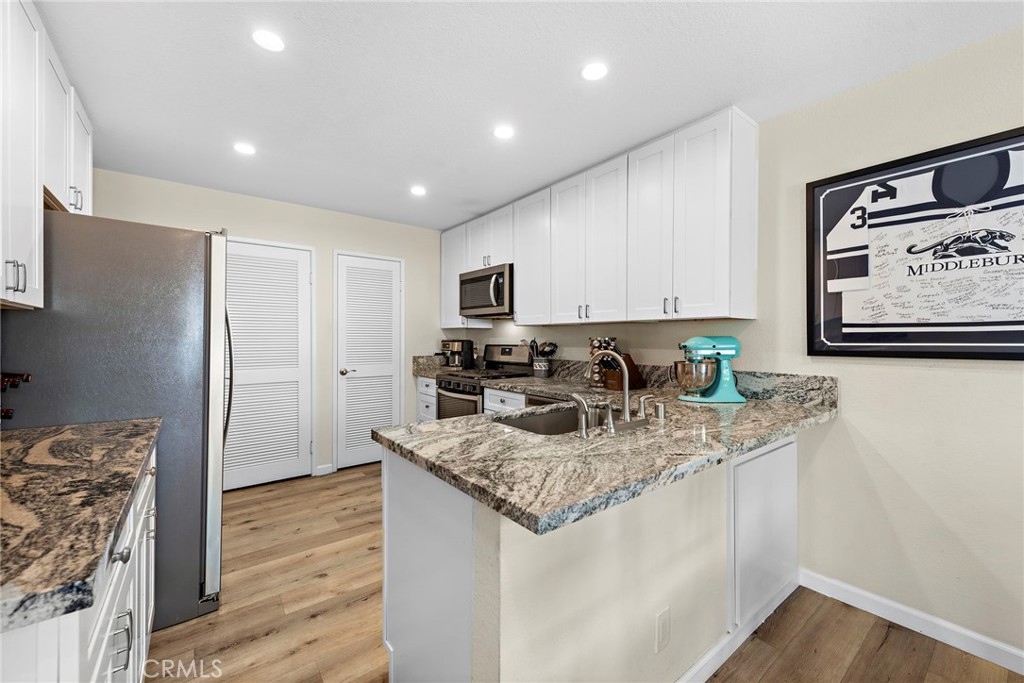 22 Exeter, Unit 23 Irvine, CA 92612 - Photo 12 of 30 a kitchen with stainless steel appliances granite countertop a sink refrigerator and cabinets
