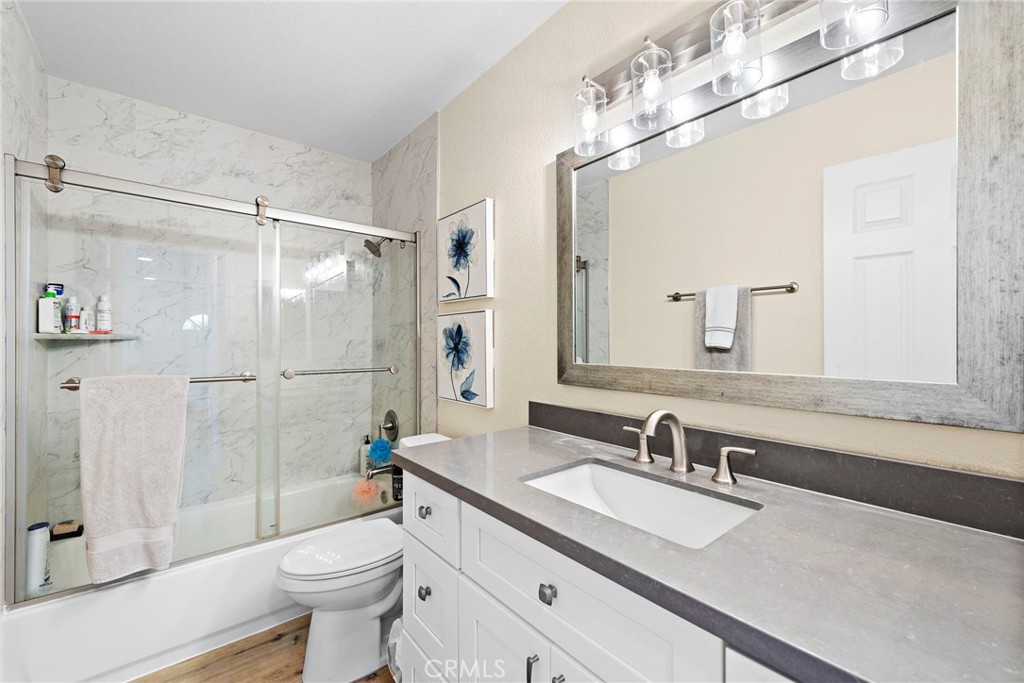 22 Exeter, Unit 23 Irvine, CA 92612 - Photo 3 of 30 a bathroom with a granite countertop sink toilet mirror and shower
