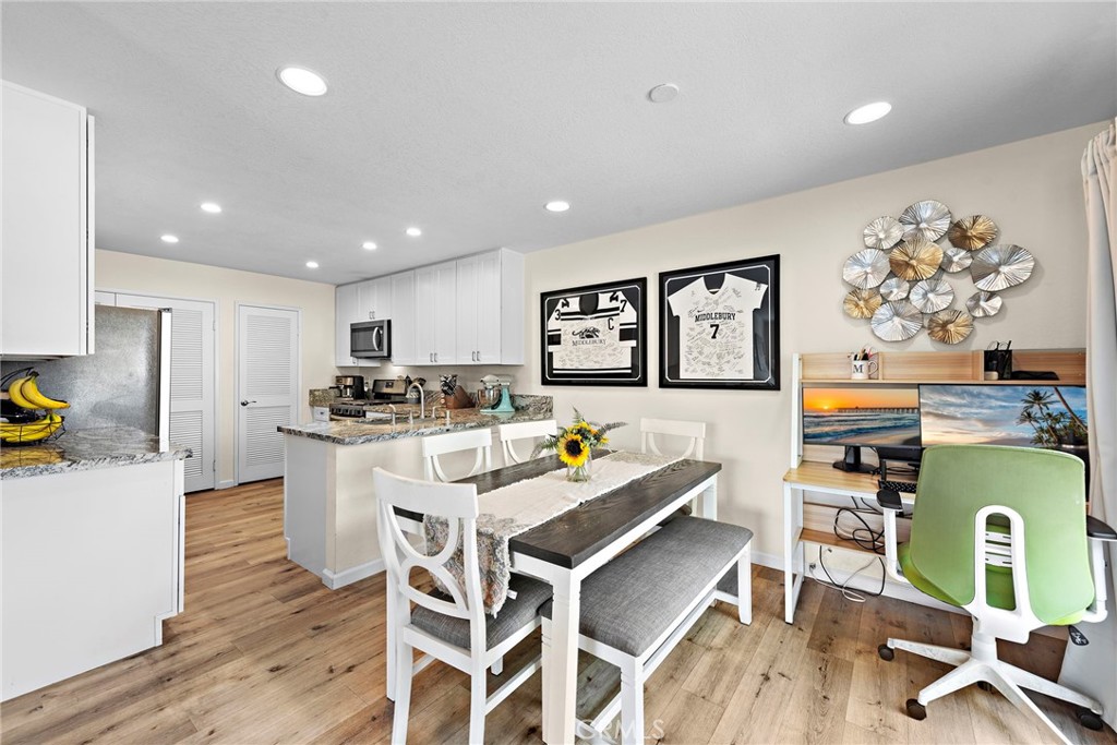 22 Exeter, Unit 23 Irvine, CA 92612 - Photo 9 of 30 a living room with furniture a dining table and kitchen view with wooden floor