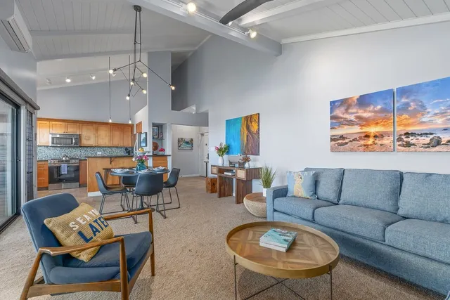 a living room with furniture kitchen and a large window