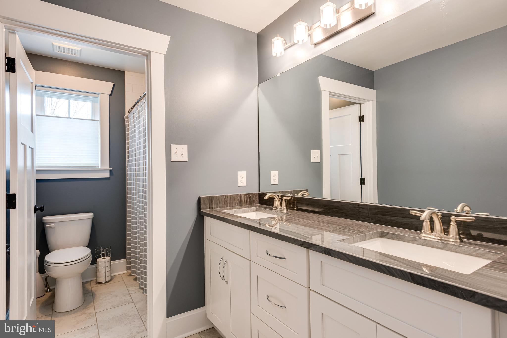 2 West 8th Street Media, PA 19063 - Photo 36 of 51 a bathroom with a granite countertop sink a toilet and a mirror