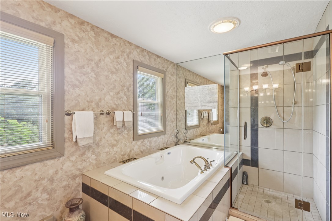4101 Huffman Road Medina, OH 44256 - Photo 25 of 48 Bathroom featuring a jetted tub, a stall shower, wallpapered walls, and a chandelier
