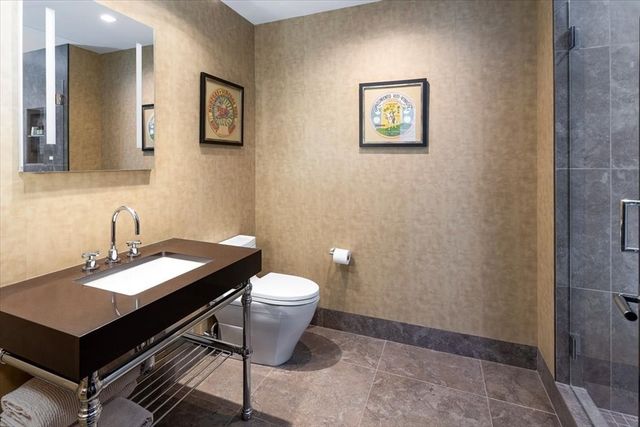 a bathroom with a granite countertop toilet and a sink