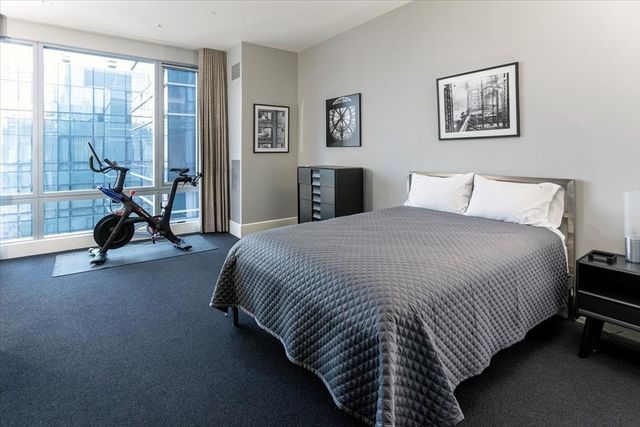 a spacious bedroom with a bed and a large window