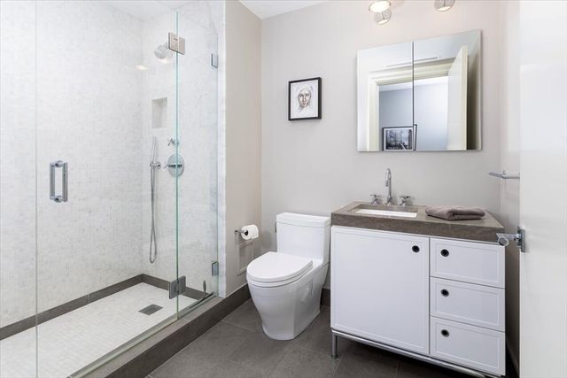 a bathroom with a double vanity sink toilet and shower
