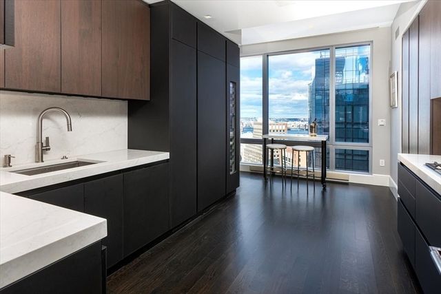 a kitchen with wooden floors wooden cabinets and a sink