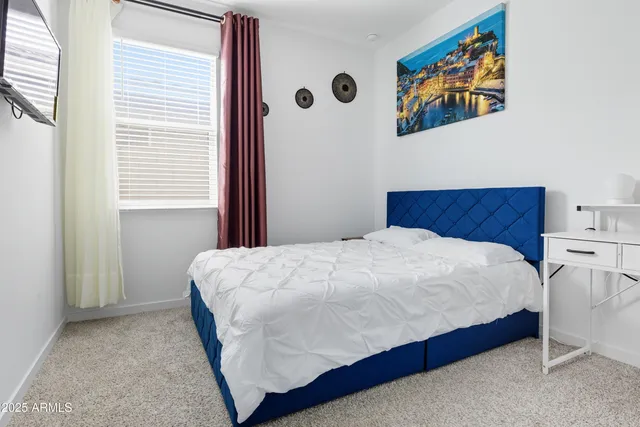 a large bed sitting in a bedroom next to a window