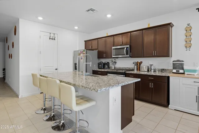 a kitchen with stainless steel appliances granite countertop a stove refrigerator sink and cabinets