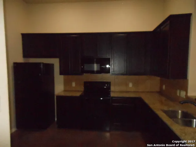a view of an empty room with wooden floor and a fireplace