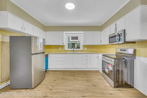 a kitchen with stainless steel appliances granite countertop a refrigerator a stove and a sink