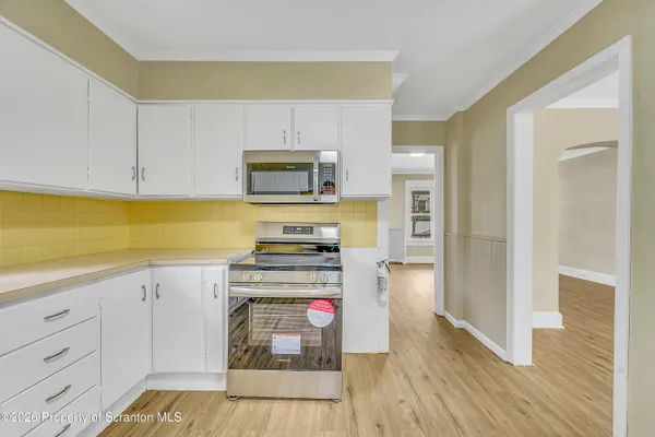 a kitchen with a refrigerator and a stove top oven