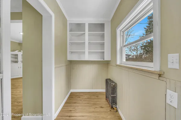 a view of a hallway with wooden floor and a window