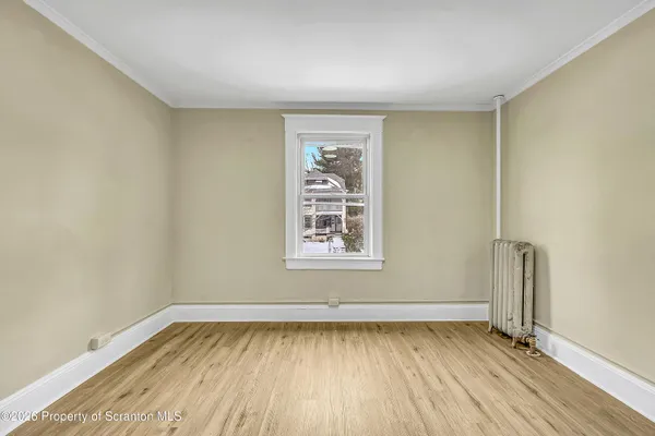 an empty room with a hardwood and window