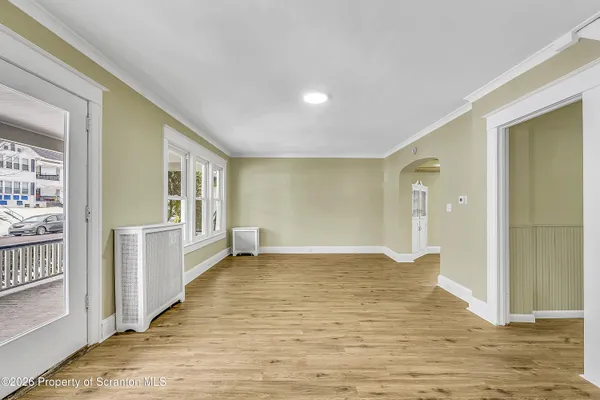 a view of a big room with wooden floor and windows