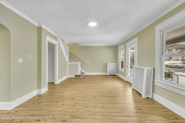a view of a big room with wooden floor and windows